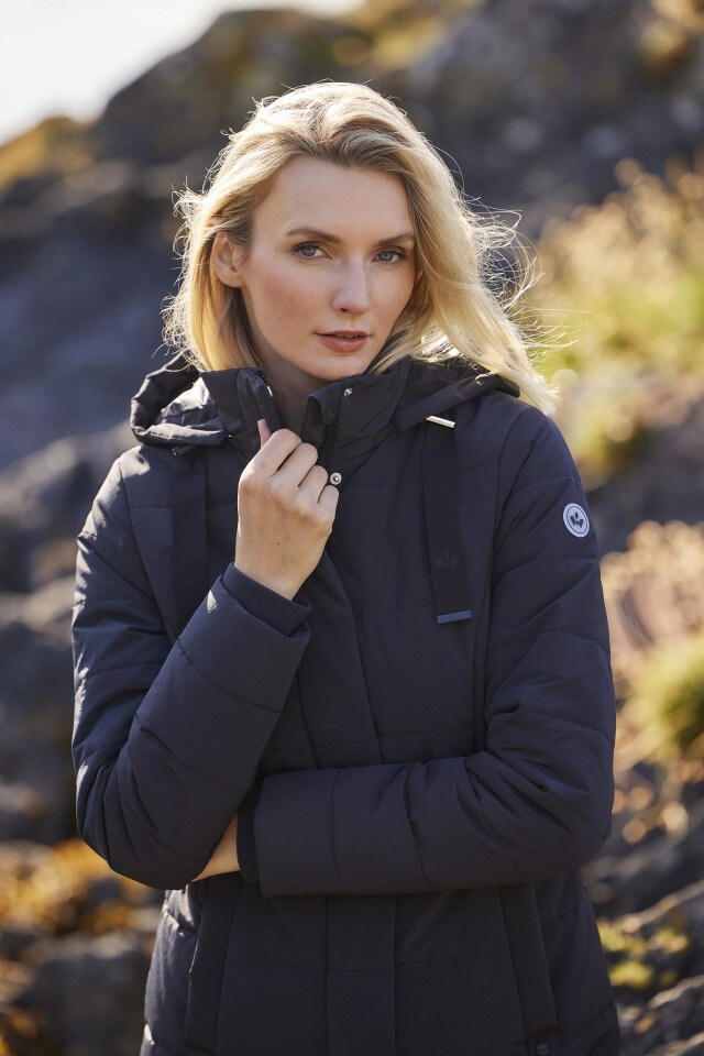 Dame trägt eine dunkelblaue Thermo-Jacke und schaut in die Kamera.