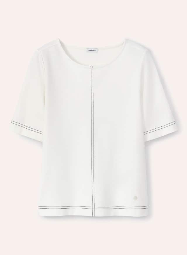 Ein weißes kurzärmeliges Oberteil mit dekorativen schwarzen Ziernähten liegt flach ausgebreitet vor hellem Hintergrund.