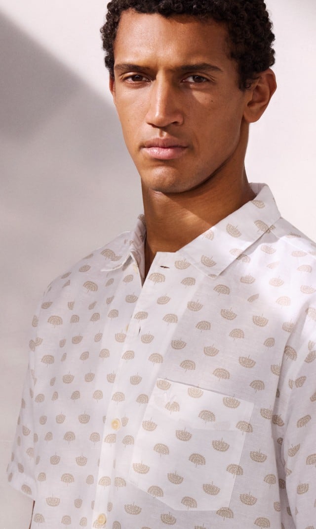 Ein Mann trägt ein weißes Hemd mit Muster.