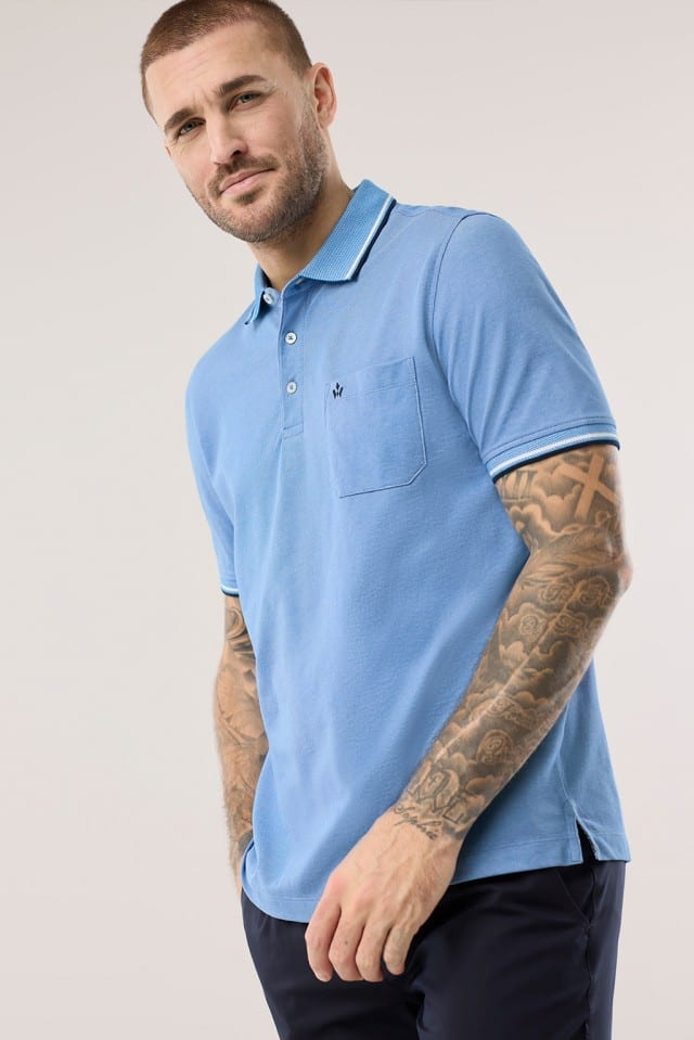 Ein Mann trägt ein Extraglatt-Polo Bicolor in Azurblau.