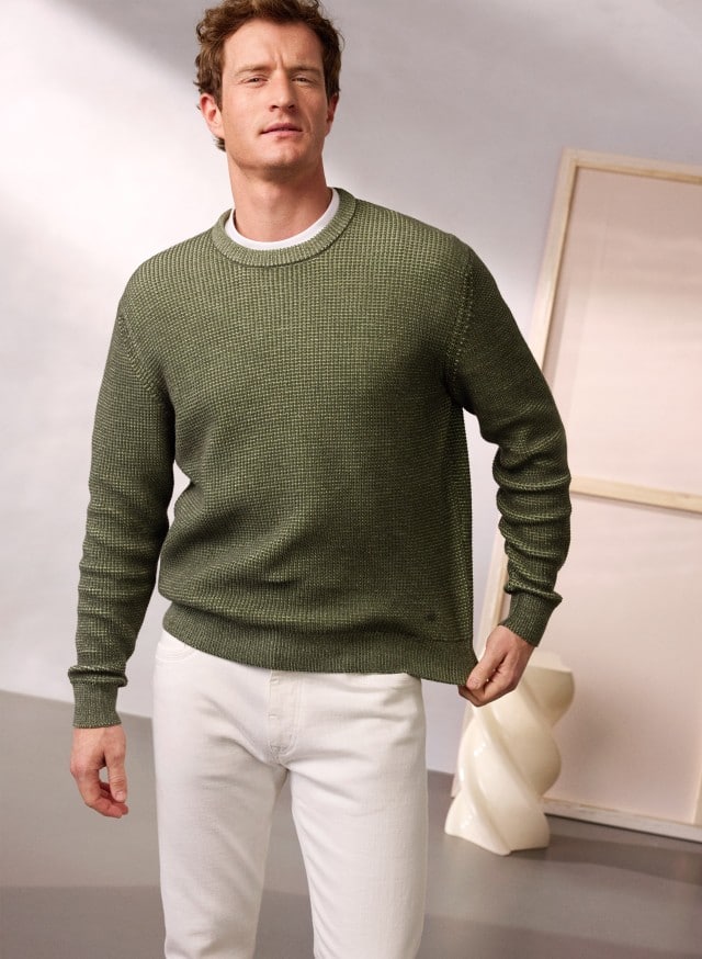 Ein Mann trägt den Strukturpullover Bicolor in Khaki, dazu eine Hose in Offwhite. Ein Mann trägt den Strukturpullover Bicolor in Khaki, dazu eine Hose in Offwhite.