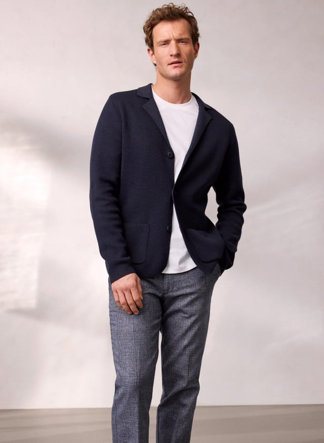 Ein Mann trägt den Milano Rib Blazer in Navy, darunter ein weißes Shirt und dazu eine Cool-Wool Chino in Marine Kariert. Ein Mann trägt den Milano Rib Blazer in Navy, darunter ein weißes Shirt und dazu eine Cool-Wool Chino in Marine Kariert.