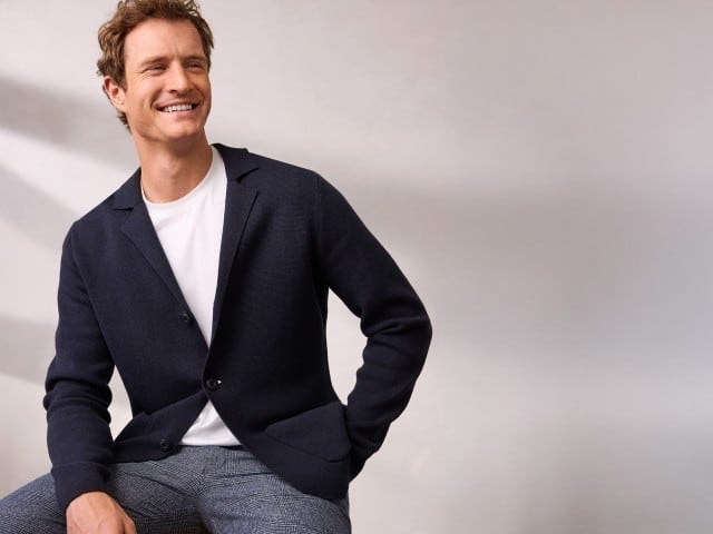 Ein Mann sitzt entspannt und trägt den Milano Rib Blazer in Navy, darunter ein weißes Shirt und dazu eine Cool-Wool Chino in Marine Kariert. Ein Mann sitzt entspannt und trägt den Milano Rib Blazer in Navy, darunter ein weißes Shirt und dazu eine Cool-Wool Chino in Marine Kariert.