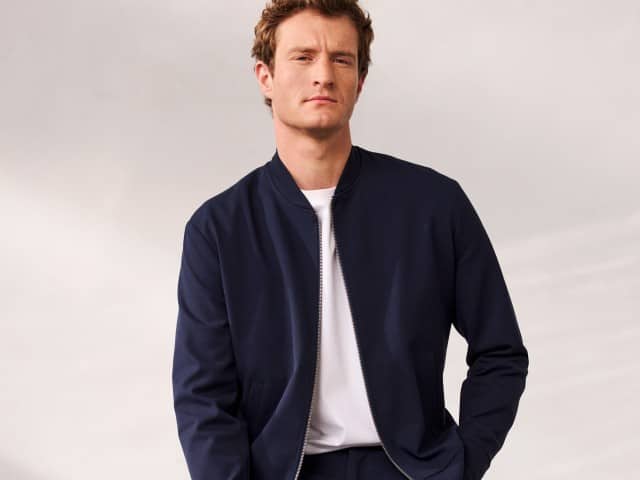 Ein Mann trägt ein Blouson mit Stehkragen in Marine, darunter ein weißes Shirt. Ein Mann trägt ein Blouson mit Stehkragen in Marine, darunter ein weißes Shirt.