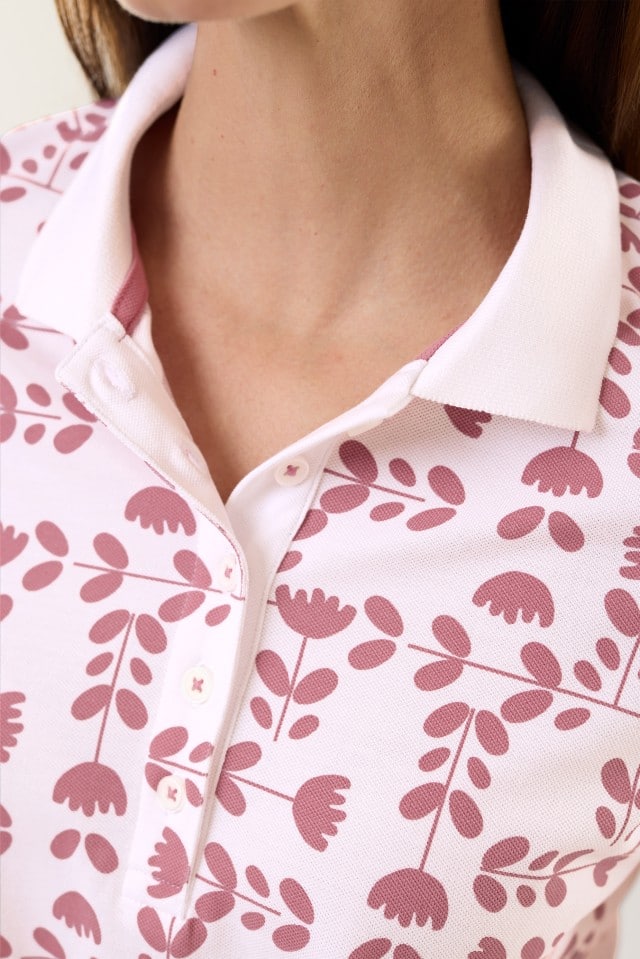 Eine Frau trägt ein Poloshirt Frischekick in der Farbe Tulpenspiel Rosenholz.