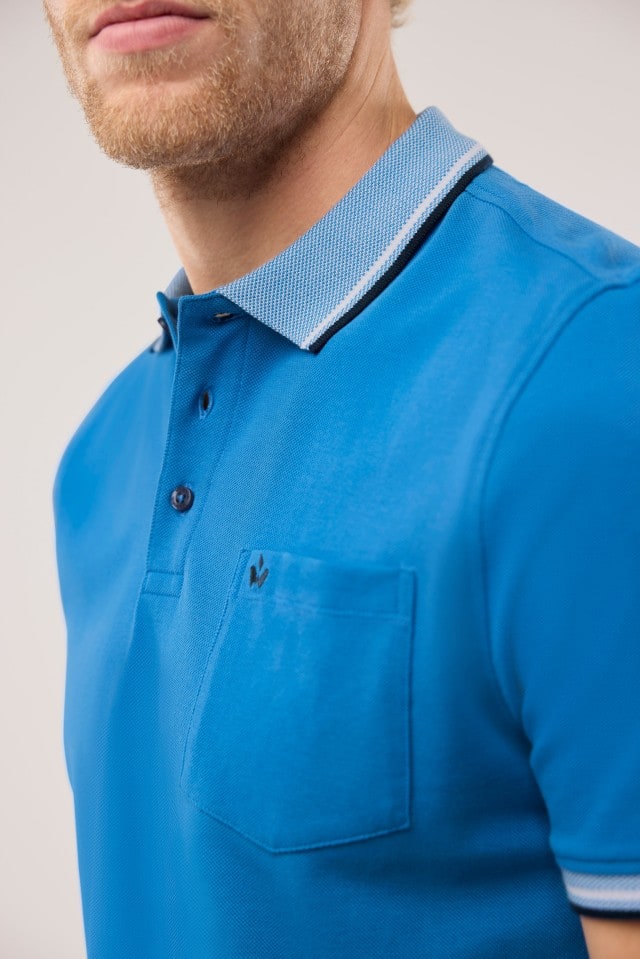 Ein Mann trägt ein Pique-Polo Hitzefrei in Uni Marineblau.
