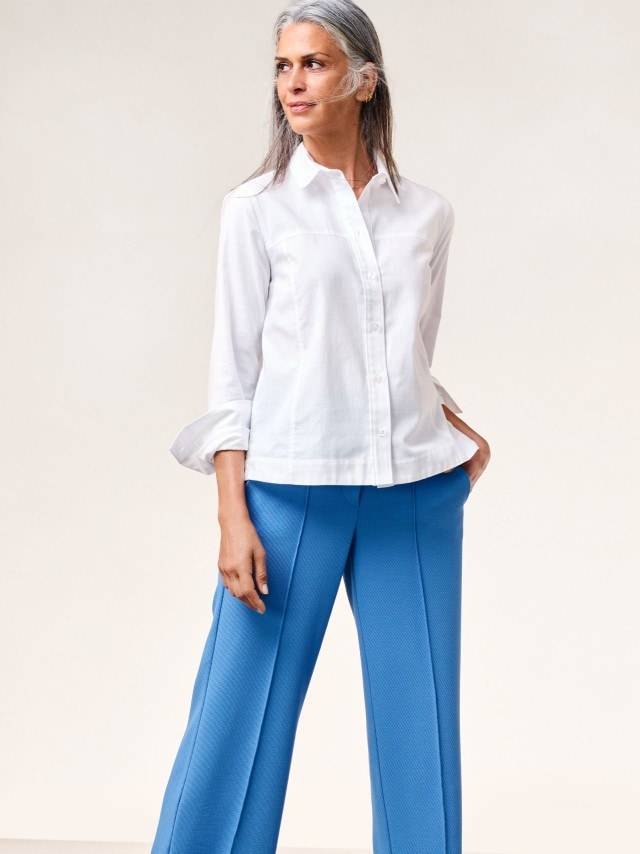 Frau in weißer Boxy Bluse und Atlantikblauer Culotte