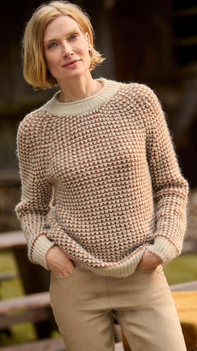 Eine Frau trägt einen Leicht&Weich Pullover in Creme/Toffee, dazu eine Yoga-Schlupfjeans in Caramel.