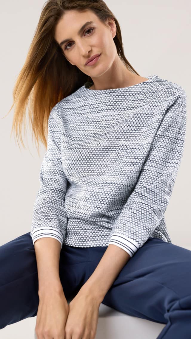 Eine Frau trägt ein Struktur Jersey Sweatshirt in Marine, dazu eine passende Hose. Eine Frau trägt ein Struktur Jersey Sweatshirt in Marine, dazu eine passende Hose.