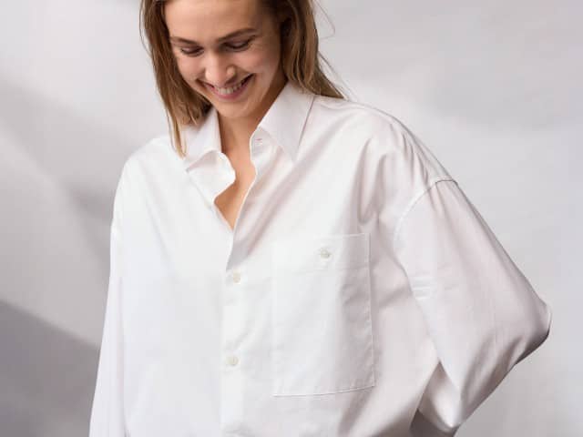 Eine Frau trägt ein weißes Oversize Hemd.