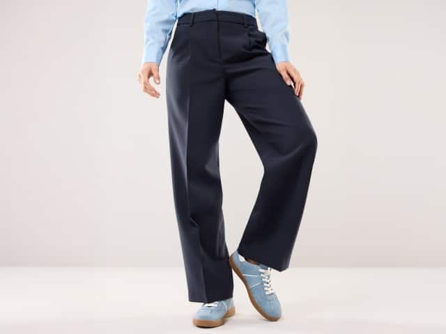 Ein Frau trägt eine weite Hose in Marine.