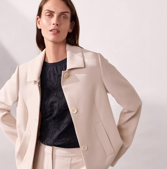 Ein Frau trägt einen Kofferblazer und eine passende Hose in Beige.