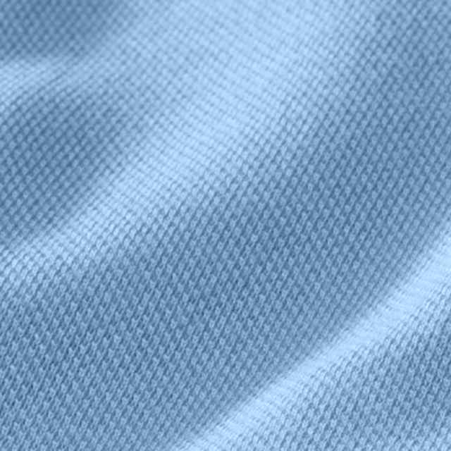 Nahaufnahme eines hellblauen Stoffes mit feiner, texturierter Webung, die leichte Falten zeigt.