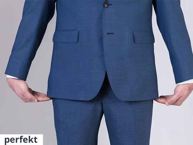 Mann trägt einen blauen Anzug und hält die Hände am Ende des Sakkos.