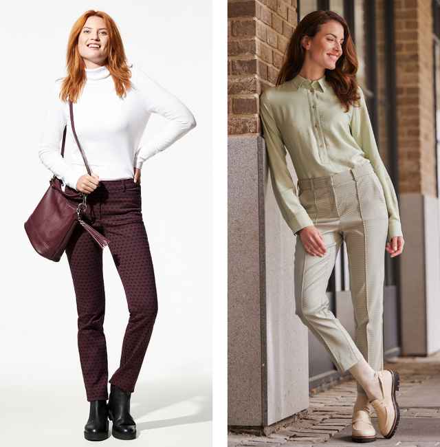Zwei Frauen in eleganten Outfits posieren; links mit weißem Rollkragen und gemusterter Hose, rechts in grünem Hemd und beiger Hose.
