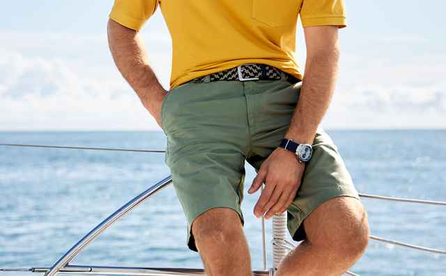 Mann trägt ein grünes Paar Shorts auf einem Boot im Wasser
