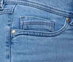 Nahaufnahme einer blauen Jeans mit sichtbarer Vordertasche, Nieten und feinen Nähten.