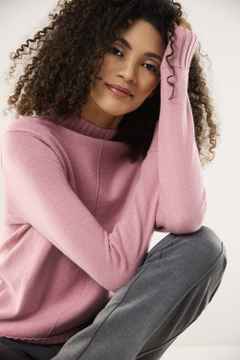 Eine Frau trägt einen Pullover mit Cashmere in Rosa.