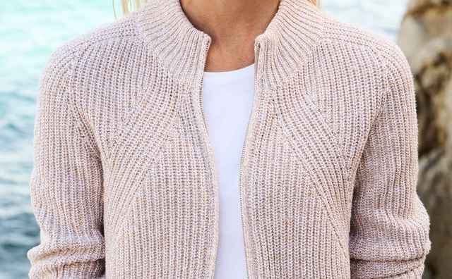 Eine Frau trägt eine Patentstrickjacke Nahtlos in Safaribeige.